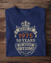 Blue t-shirt with 'Made in 1975, 50 years of being awesome' text on a wooden surface.